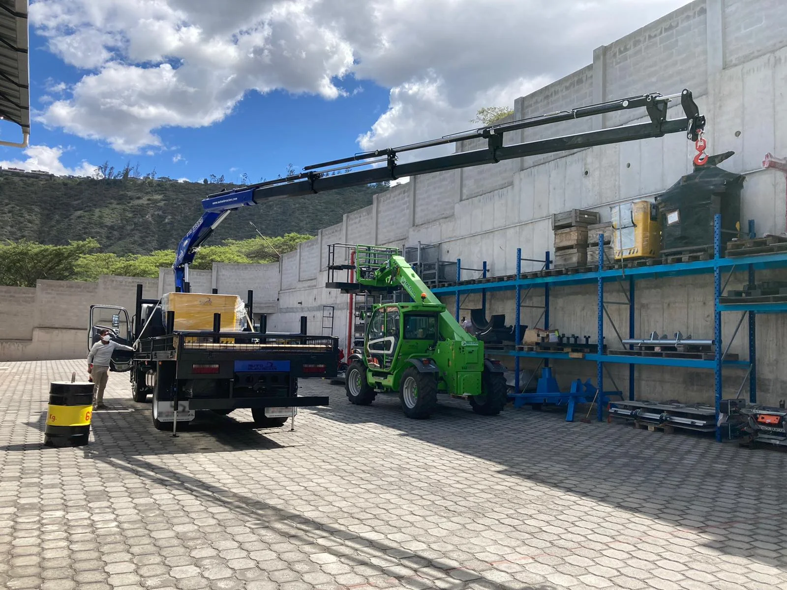 DILEXSA crane truck loading industrial equipment at a warehouse — lifting capacity and heavy load maneuvering